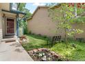 Inviting front yard showcasing lush greenery, flower beds, and a cozy bench at 2181 E Phillips Ln, Centennial, CO 80122