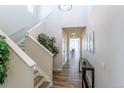 Bright hallway with wood floors, leading to other rooms, featuring a staircase with white railings at 1135 Basalt Ridge Loop, Castle Rock, CO 80108