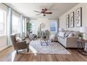 Cozy living room with large windows, a ceiling fan, and comfortable seating arrangement at 1135 Basalt Ridge Loop, Castle Rock, CO 80108