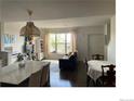 Inviting living space featuring a large window, dining area, and modern decor for comfortable living at 9637 E 56Th Pl, Denver, CO 80238
