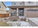 Charming front entrance with a covered porch, stone accents, and manicured landscaping at 25126 E Bayaud Pl, Aurora, CO 80018