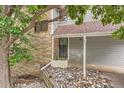 Townhome entrance featuring brick accents, siding, and mature landscaping at 8795 W Cornell Ave # 1, Lakewood, CO 80227