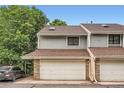 Townhome exterior with an attached garage, brown roof, and gray siding at 8795 W Cornell Ave # 1, Lakewood, CO 80227