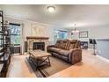 Living room featuring a stone fireplace, wood floors, and a comfortable brown sofa at 8795 W Cornell Ave # 1, Lakewood, CO 80227