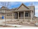 Charming home with covered porch, two-car garage, and low maintenance landscaping with blue sky at 8099 Arapahoe Peak St, Littleton, CO 80125