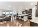 Open kitchen features granite countertops, stainless steel appliances and a large island with barstool seating at 8099 Arapahoe Peak St, Littleton, CO 80125