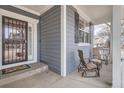 Inviting front porch featuring neutral-toned chairs and a view of the home's siding with black shutters at 10551 Redcone Way, Highlands Ranch, CO 80130