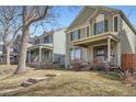 View of a house showing its front yard with mature trees and a neatly maintained lawn at 2650 Perry St, Denver, CO 80212