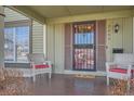 Inviting covered front porch with seating area, perfect for relaxing and enjoying the outdoors at 2650 Perry St, Denver, CO 80212