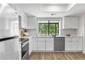 Bright kitchen featuring white cabinets, stainless steel appliances, and a window with a view of the trees at 12662 E Warren Dr # F, Aurora, CO 80014