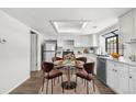 Eat-in kitchen features modern white cabinetry, stainless appliances, hardwood floors, and table for four at 12662 E Warren Dr # F, Aurora, CO 80014