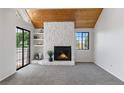 Cozy living room featuring a stone fireplace, wood ceiling, and sliding glass doors at 12662 E Warren Dr # F, Aurora, CO 80014