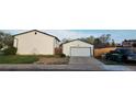Spacious detached garage with white door and ample parking space alongside a well-kept lawn at 13661 W Tufts Ave, Morrison, CO 80465