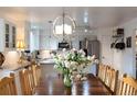 Elegant dining area boasts a hardwood table, chandelier, and an open view of the modern kitchen with stainless steel appliances at 7189 S Kline St, Littleton, CO 80127