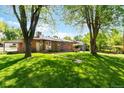 Expansive backyard with lush green lawn and mature trees, perfect for outdoor activities and relaxation at 6314 Brooks Dr, Arvada, CO 80004
