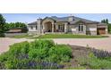 Charming home with manicured lawn and inviting entrance, featuring stone accents and a spacious driveway at 13962 W 76Th Ln, Arvada, CO 80005