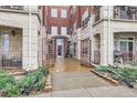 Exterior view of an open gate leading to a courtyard with manicured landscaping and building entrance at 2100 N Humboldt St # 207, Denver, CO 80205