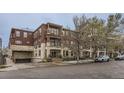 Apartment building featuring a brick facade, balconies, and underground parking at 2100 N Humboldt St # 207, Denver, CO 80205