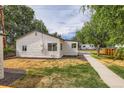 Side yard shows manicured plantings and sidewalk leading to the main home at 5147 Saint Paul St, Denver, CO 80216