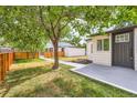 View of the backyard with a concrete patio area and mature tree at 5147 Saint Paul St, Denver, CO 80216