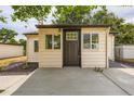 Rear view of the detached garage shows door, concrete apron and two windows at 5147 Saint Paul St, Denver, CO 80216