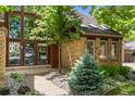 Charming brick home featuring a front door with sidelights and detailed front yard landscaping at 10886 E Crestline Cir, Englewood, CO 80111