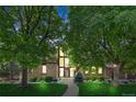Inviting brick home boasts a striking front facade with large windows and mature trees at 10886 E Crestline Cir, Englewood, CO 80111