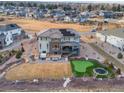 Aerial view of the backyard with a putting green, trampoline, patio, and hot tub, surrounded by landscaped grounds at 26 Damsire Dr, Littleton, CO 80123