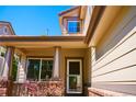 Inviting covered porch with brick accents, offering a cozy entrance to the home at 4788 Laurelglen Ln, Highlands Ranch, CO 80130
