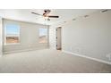 Bright bedroom with carpet, ceiling fan, two windows letting in natural light, and neutral walls at 17942 E 94Th Pl, Commerce City, CO 80022