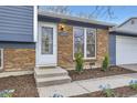 Close-up of a charming brick home, highlighting the front door, address, and neatly manicured landscaping at 9921 Wigham St, Thornton, CO 80229