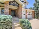 Inviting front entrance with brick columns and a well-manicured landscape at 7053 S Shawnee St, Aurora, CO 80016
