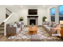 Virtually staged living room with fireplace and large windows at 810 N Vandriver Way, Aurora, CO 80018