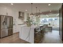 Bright, modern kitchen with a waterfall island, stainless steel appliances, and open access to the living space at 5880 Beeler Ct, Denver, CO 80238
