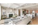 Bright living room with fireplace, hardwood floors, and an open layout leading to the kitchen at 5880 Beeler Ct, Denver, CO 80238