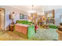 A comfortable living room features plush green furnishings, decorative lamps and green carpet at 2421 N York St, Denver, CO 80205