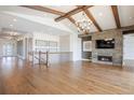 Spacious living room features hardwood floors, wood beams, a cozy fireplace, and staircase with metal railings at 27381 E Lakeview Dr, Aurora, CO 80016