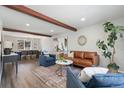 Open concept living room with brown leather sofa, beams, and large picture window at 7076 W 83Rd Way, Arvada, CO 80003