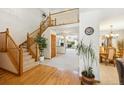 Spacious foyer with hardwood floors, a staircase, and views of the living and dining areas at 5134 S Ouray Ct, Centennial, CO 80015