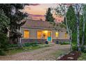 A single story house with a tan exterior, stone base, gravel driveway and a turquoise colored front door at 9390 W 14Th Ave, Lakewood, CO 80215