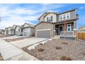 Two story house on a tree lined street with gray siding and stone accents at 13402 E 110Th Way, Commerce City, CO 80022