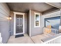 Front porch with gray door and white railings at 13402 E 110Th Way, Commerce City, CO 80022