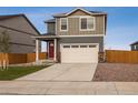Two-story home with a two-car garage, red door, and a neatly landscaped front yard at 816 Leeward St, Lochbuie, CO 80603