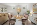 Beautiful dining room features natural light and wooden dining table set for six with elegant decor at 10062 Southlawn Cir, Commerce City, CO 80022