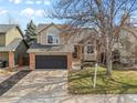 Inviting two-story home with brick accents, a lush front lawn, and an attached two-car garage for convenience at 96 S Lindsey St, Castle Rock, CO 80104