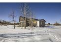 The back of the house showcasing a large deck and surrounding trees at 4022 Arleigh Dr, Berthoud, CO 80513