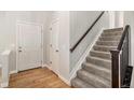 Bright entryway featuring hardwood floors, a coat closet, and a staircase with carpeted steps and a wooden handrail at 359 Wessex Cir, Highlands Ranch, CO 80126