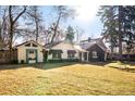 Charming backyard with lush lawn, mature trees, and ivy-covered home exterior at 1602 Glen Bar Dr, Lakewood, CO 80215