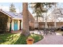 Private brick patio featuring a wrought iron table and chairs, shaded by a mature tree at 1602 Glen Bar Dr, Lakewood, CO 80215