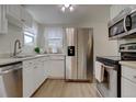 Well-lit kitchen featuring stainless steel appliances, ample counter space, and white cabinets at 1275 S Wolff St, Denver, CO 80219